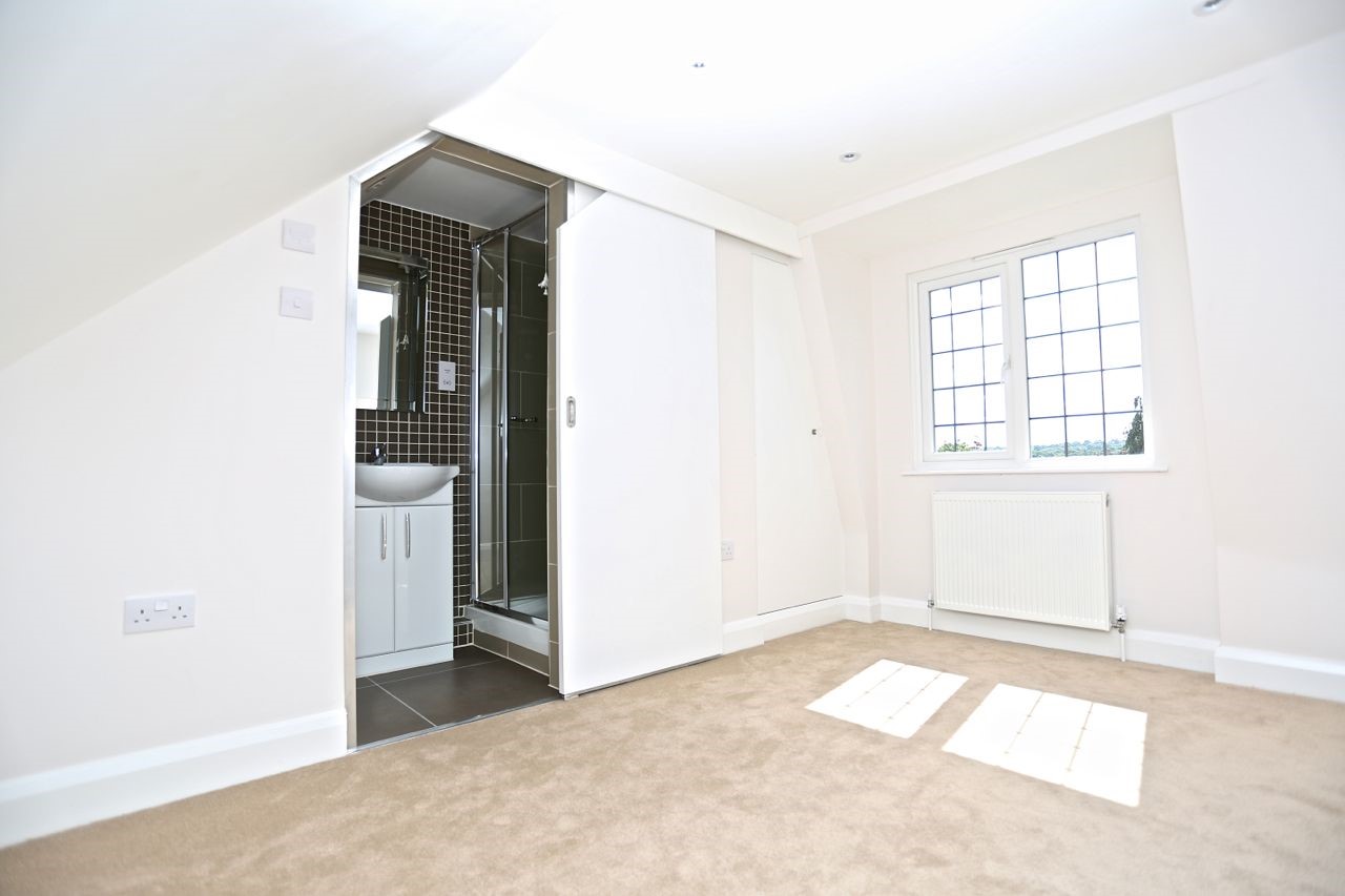 Loft bedroom on Hereward Avenue with a window overlooking the garden and a sliding door to the en-suite shower room